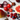 Red onion, tomato, raspberries, blueberries, pink grapefruit, apple, and a spoon of cacao powder on a white background.